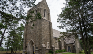 Photo By Susan Moriarty | Cathedral of the Air, a nearly century-old chapel styled in Norman-Gothic architecture, stands out from its surroundings in Lakehurst, N.J., July 25, 2024. Located near Naval Support Activity Lakehurst’s main gate, the chapel contains 18 unique stained glass windows displaying the history of aviation along with other poignant moments in American history. 